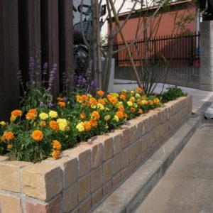 サンドストーンのピンコロで積んだ花壇とウリン列柱。